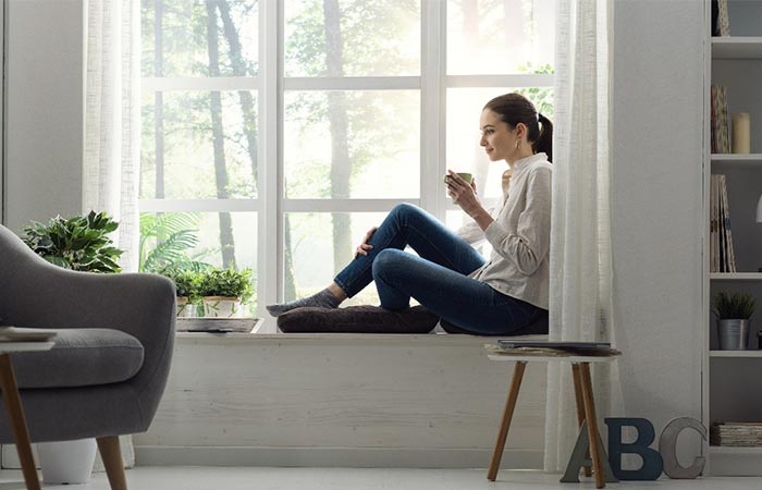 Woman-Sitting-on-Window-Ledge